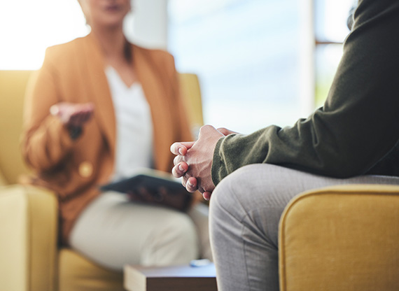 Image of therapist conversing with an individual in a mental health setting